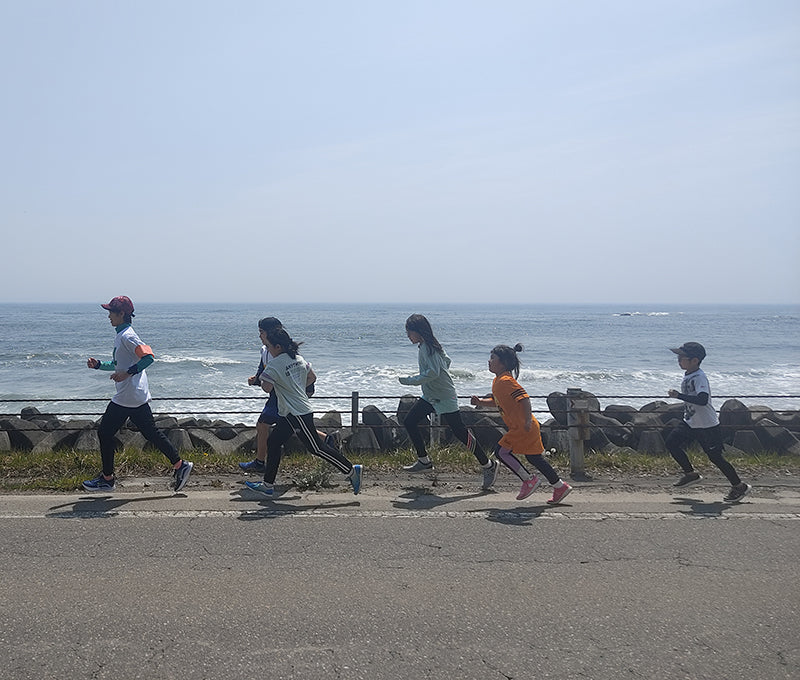 海沿いの道路を走る子供達